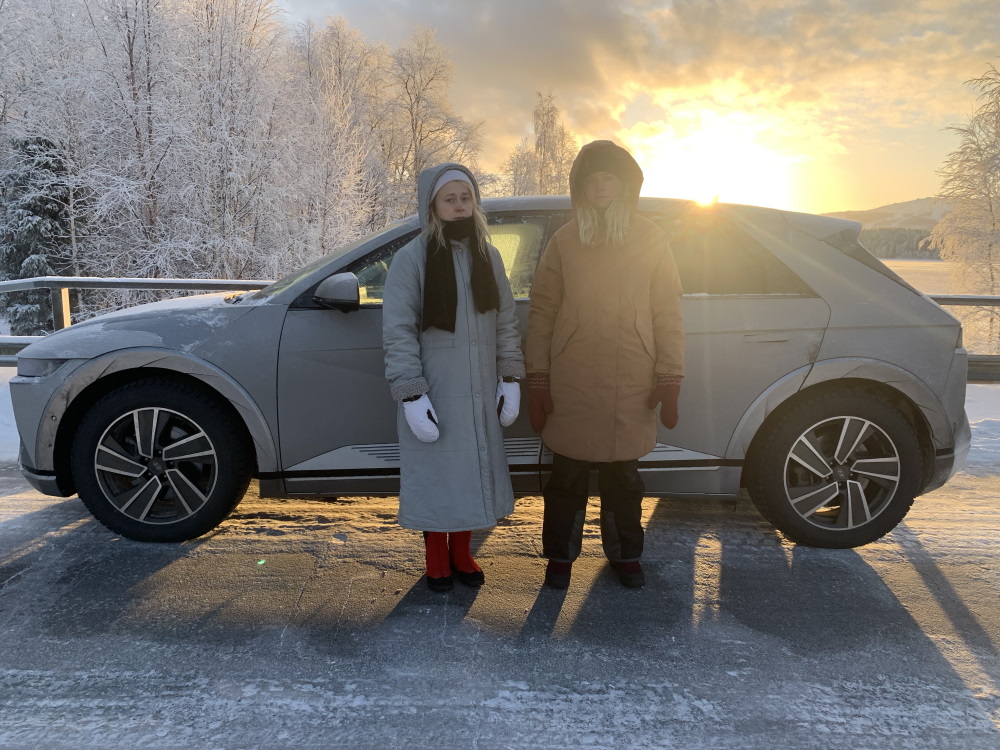 Maustetytöt Kaisa ja Anna Karjalainen lumisessa maisemassa IONIQ 5:n kanssa