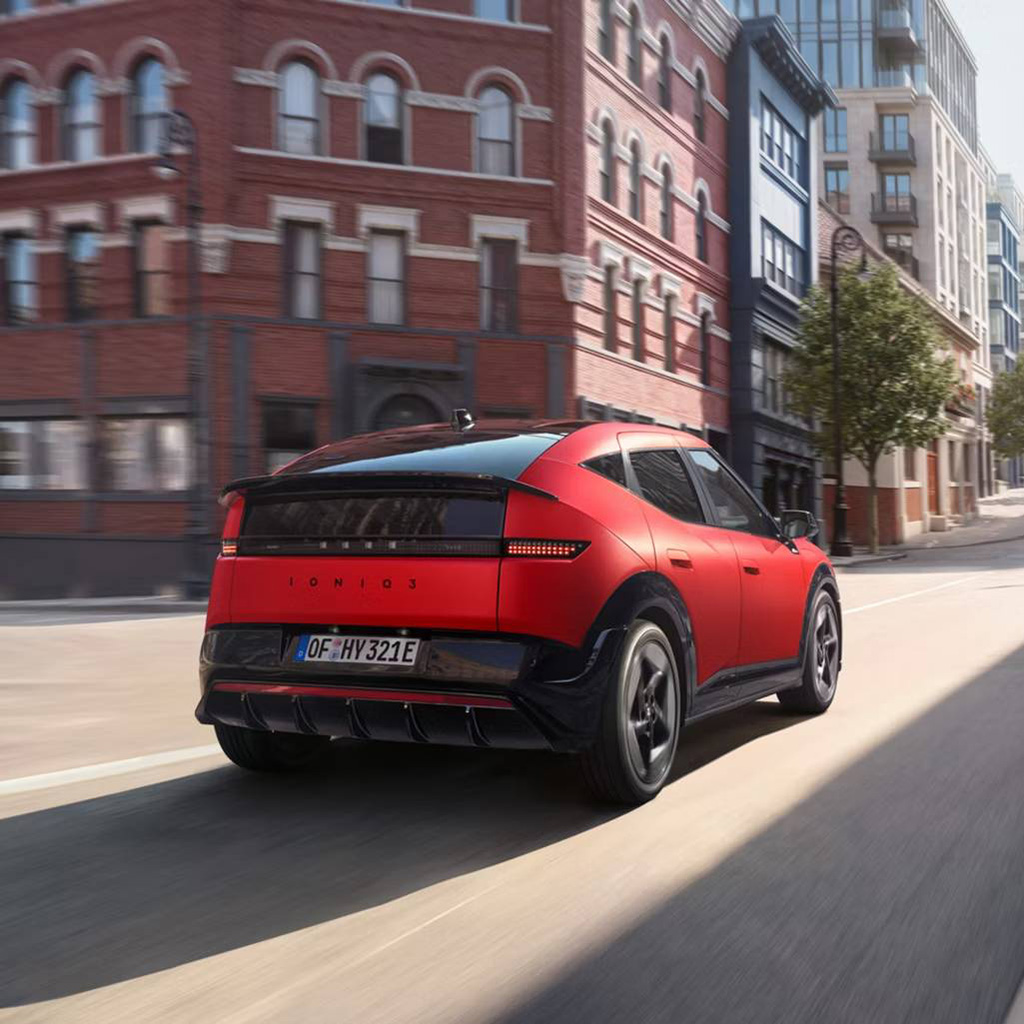 Hyundai IONIQ 3 N Line takaa kuvattuna ajossa tyhjällä kaupungin kadulla